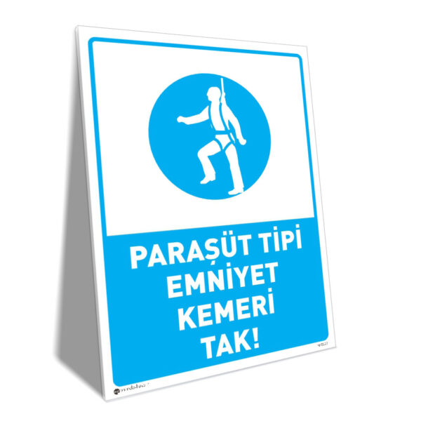Turkish safety sign urging to wear a parachute‑type safety belt: 'PARAŞÜT TİPİ EMNİYET KEMERİ TAK!'