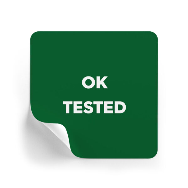 Green rounded-square sticker with the words 'OK TESTED' in white, curl at the bottom-left corner indicating a peel-off label